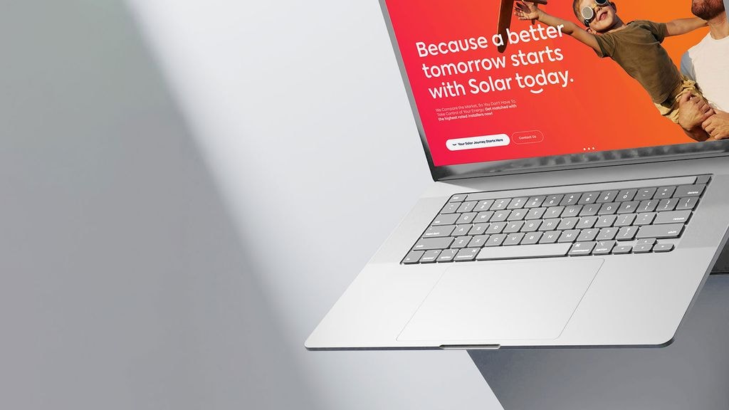 A laptop showing a compare solar provider website against a white backdrop
