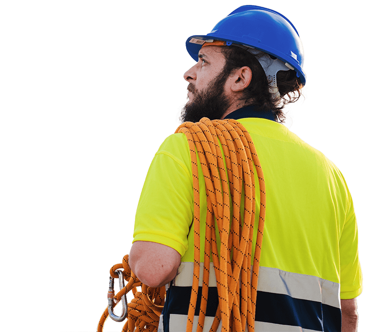 A workman looking left with his back turned towards the camera holding a rope